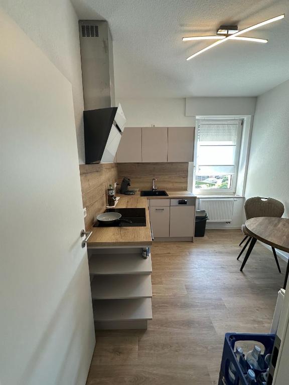 a kitchen with white cabinets and a table in it at Apartamens Henry in Lippstadt