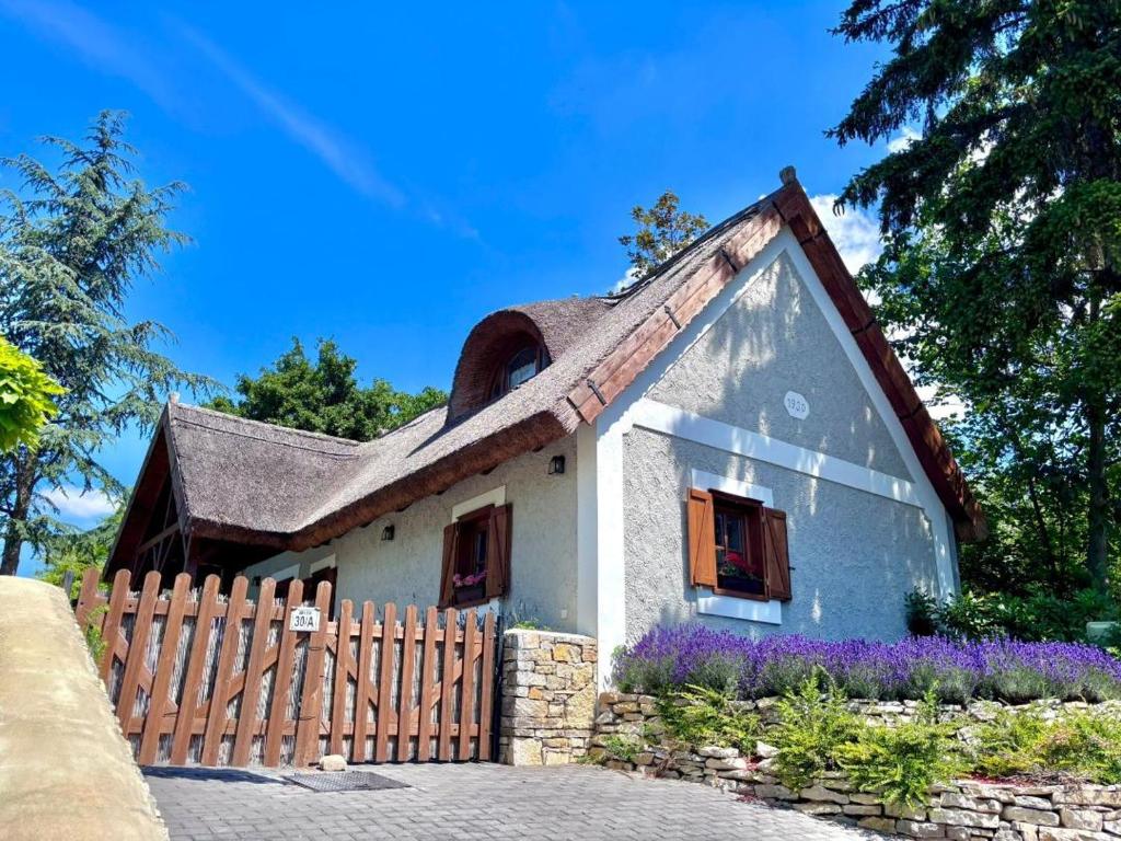a small house with a fence in front of it at Thatched cottage in Dörgicse