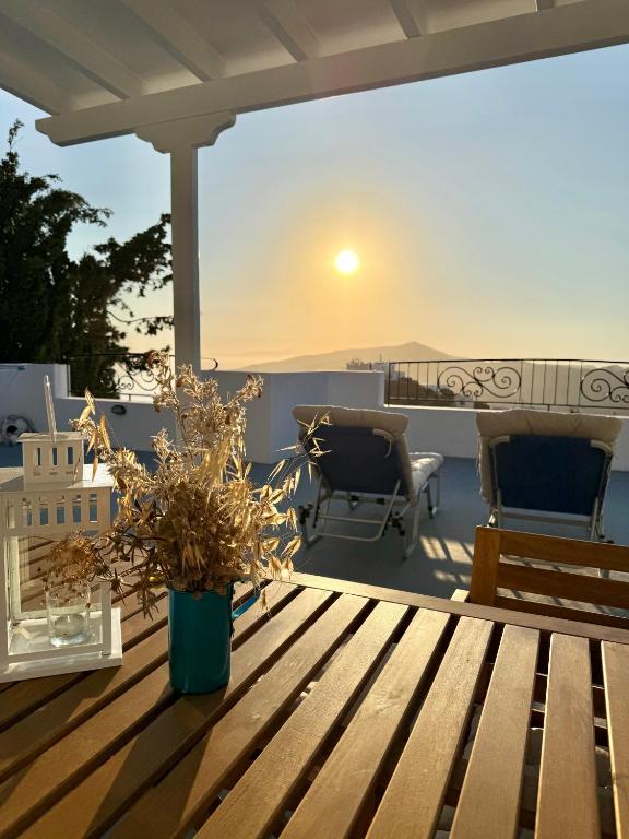 a wooden table on a deck with a view of the ocean at Villa Fenia in Aegiali