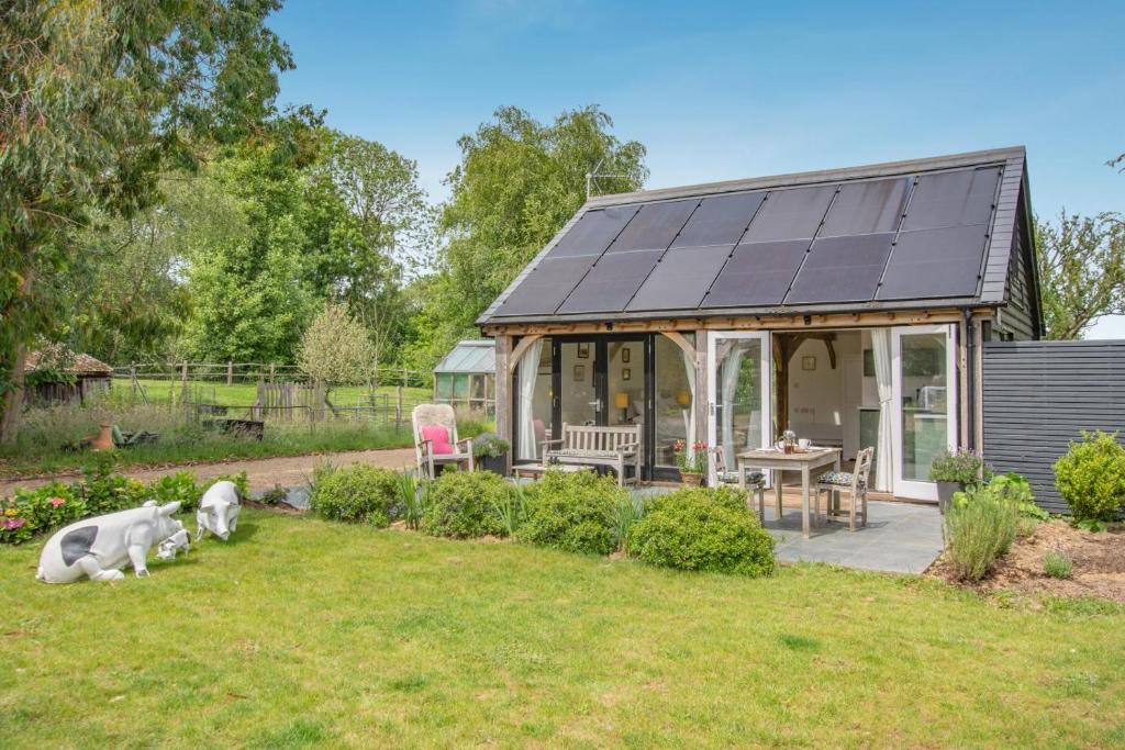 a house with a solarium and a dog laying in the yard at 1 Bed in Piltdown oc-42814 in Newick