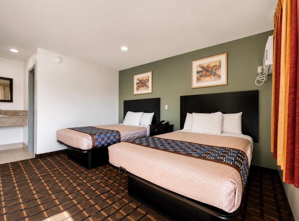 a hotel room with two beds in it at Budget Inn Ada in Ada