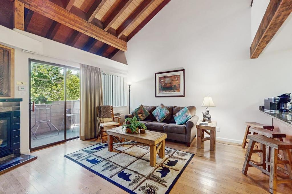 a living room with a couch and a table at Beautiful Condo with private beach access & shared pools in South Lake Tahoe