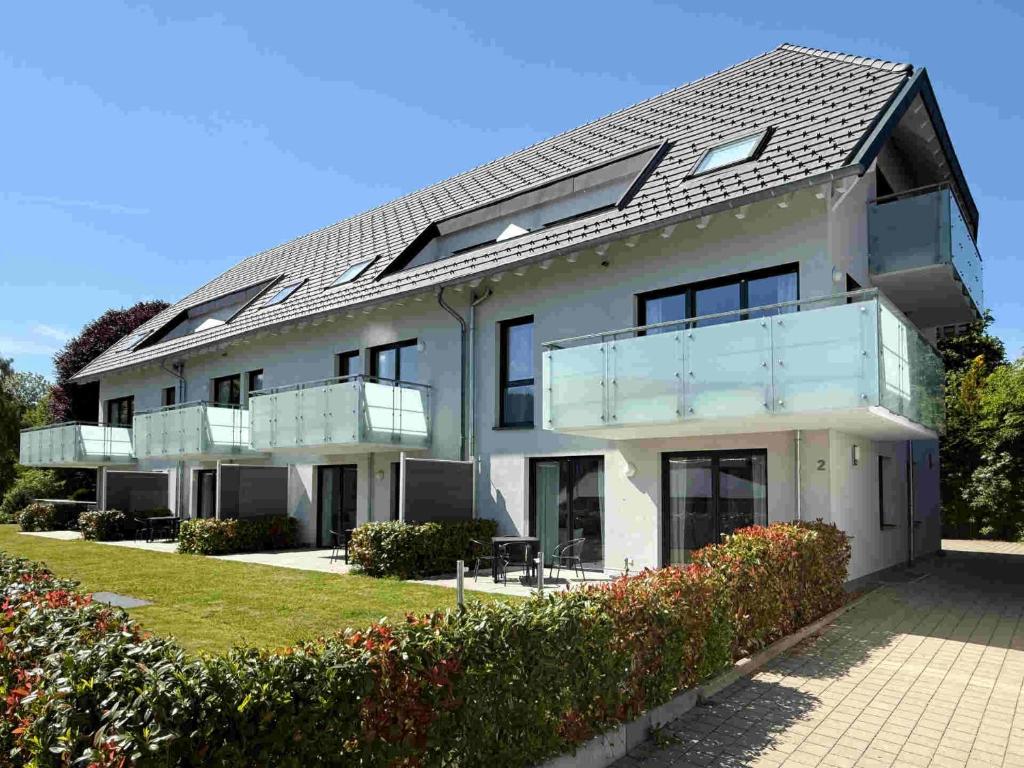 a large white house with a balcony at Mira Premium Residences - Hinterzarten in Hinterzarten