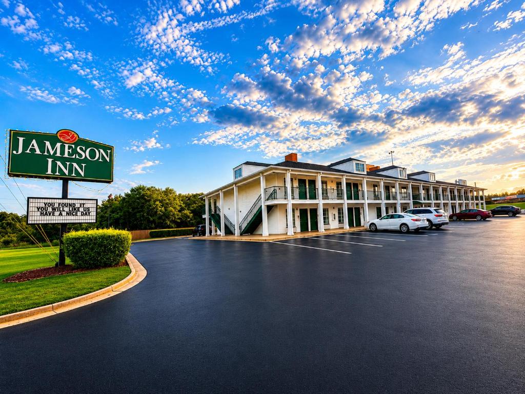 a hotel with cars parked in a parking lot at Jameson Inn - Perry in Perry