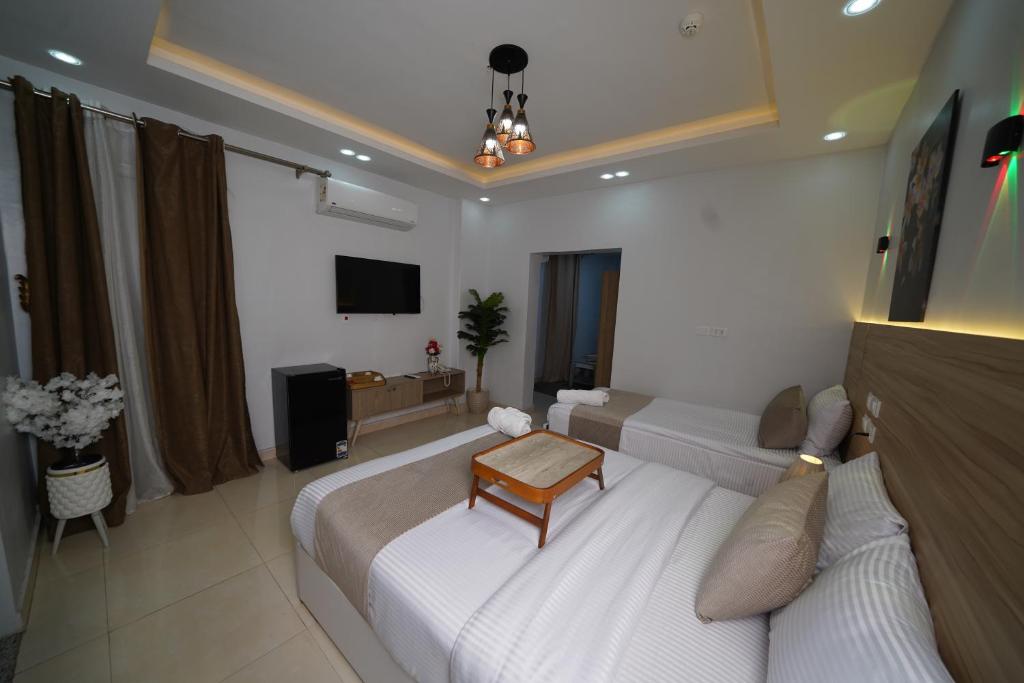 a hotel room with two beds and a television at Triple garden view hotel in Cairo