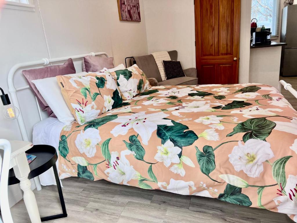 a bedroom with a bed with a floral bedspread at Short Stay- YOUR OWN GUESTHOUSE! in Halcombe