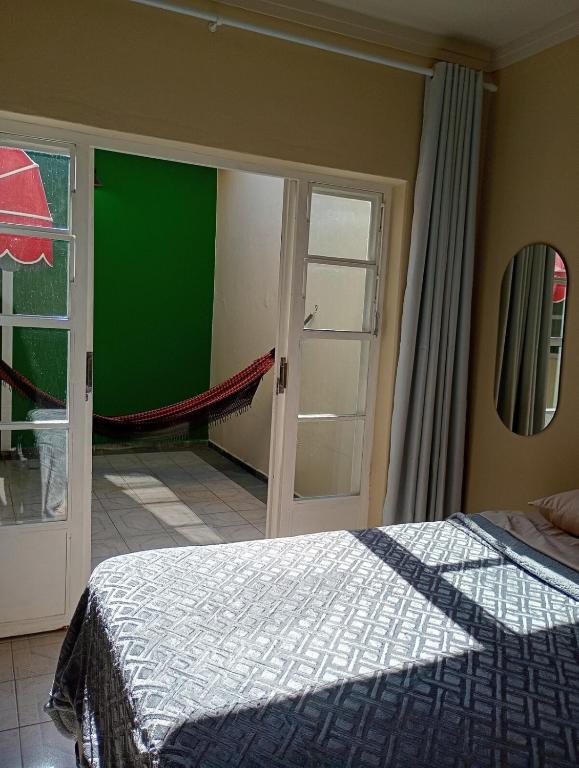 a bedroom with a bed and a sliding glass door at Loft no Centro, pertin de tudo! in Itanhandu