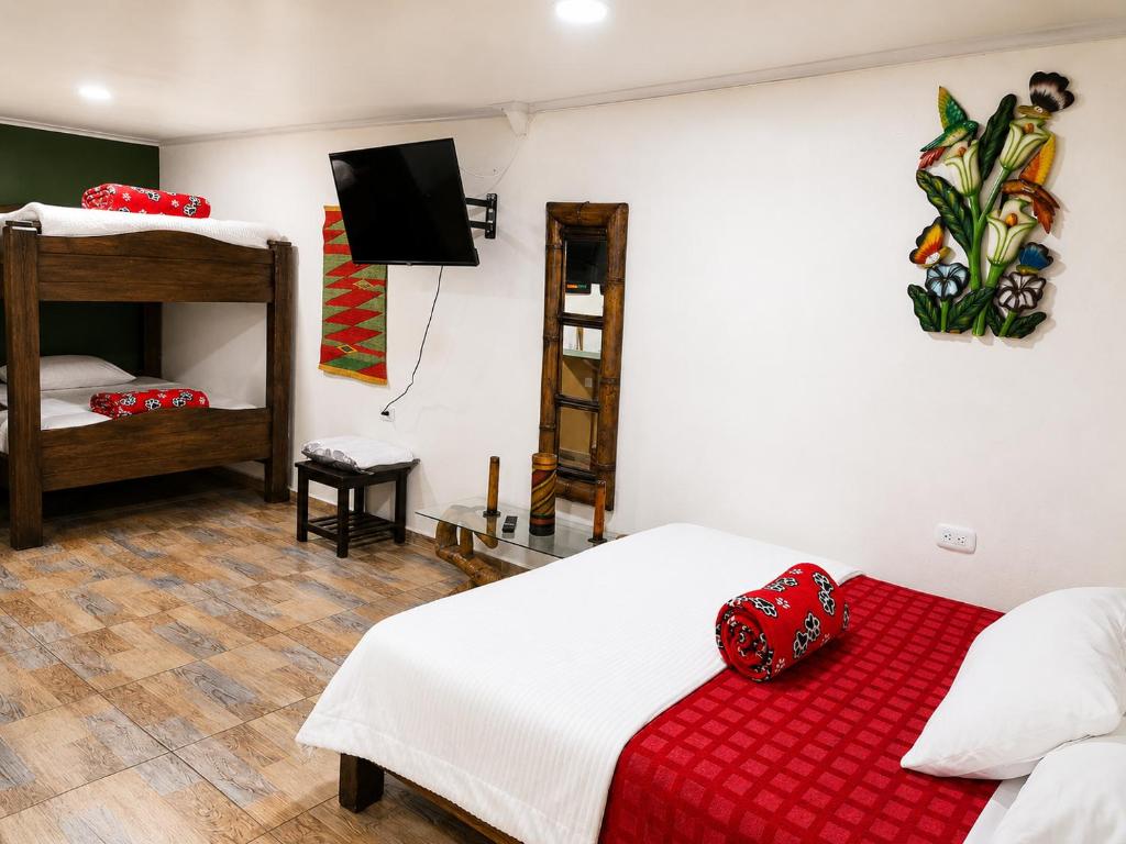 a bedroom with a bed with a red blanket at Central Apartment Salento Colombia in Salento