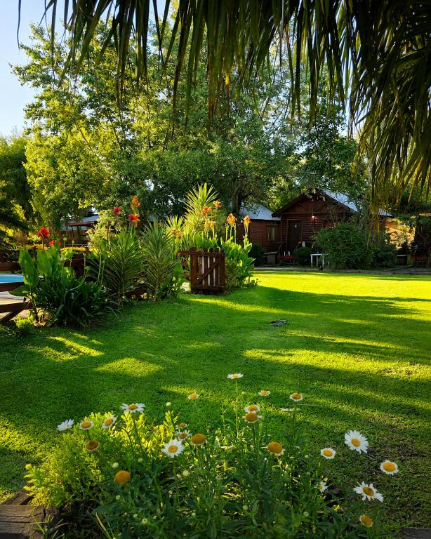 a lawn with flowers and plants in a yard at Cabañas Pulmahue in Colón