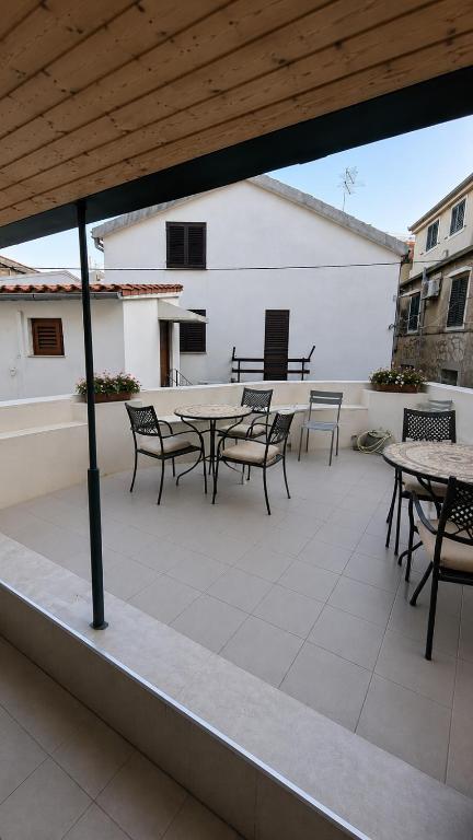 a patio with tables and chairs on a building at Guest House Emilio 1 in Split