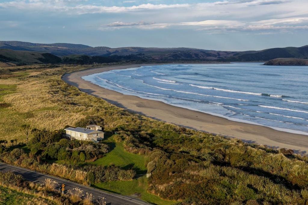 an aerial view of a house next to the beach at Hideaway Beach Cottage in Curio Bay