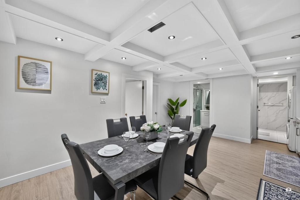 a dining room with a table and chairs at Modern and spacious 3-BR basement suite in Vancouver