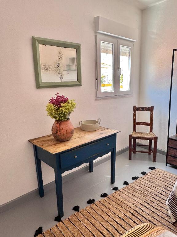 a room with a table with a vase of flowers on it at Casa das Portas de Évora in Estremoz