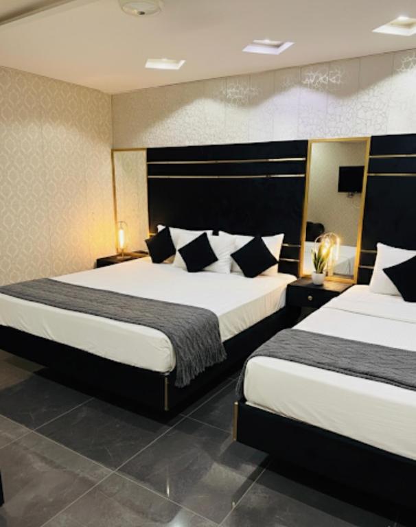 a hotel room with two beds in a room at Hotel Golden in Lahore