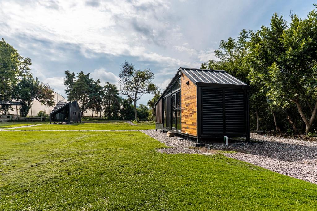 a small black cabin in a grassy field at Rosalia Haras Glamping - Experiencia ecuestre in Atlixco