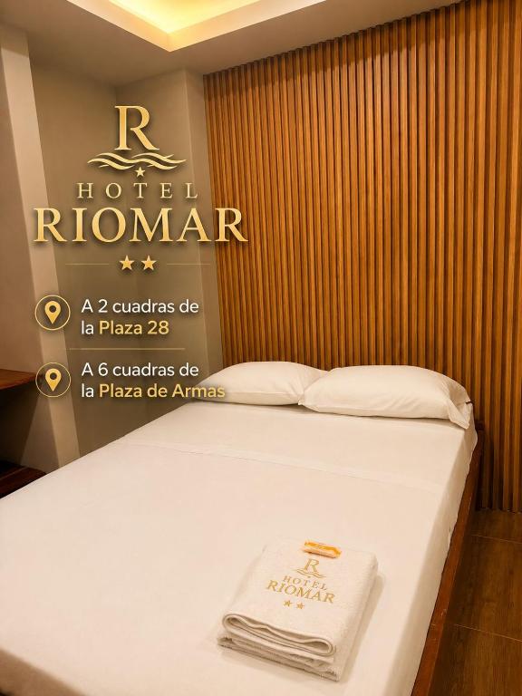 ein Hotelzimmer mit einem Bett, an dem ein Schild befestigt war in der Unterkunft Hotel Riomar in Iquitos