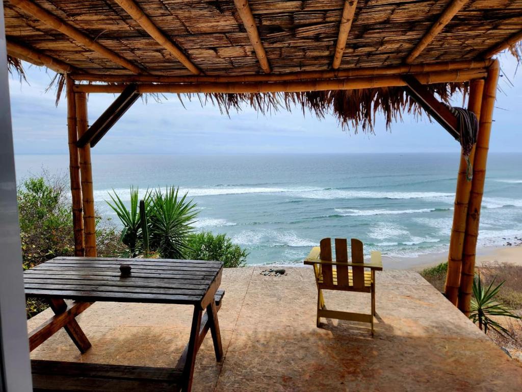 a picnic table and a chair on the beach at Casa Las Mantas Santa Marianita in Santa Marianita