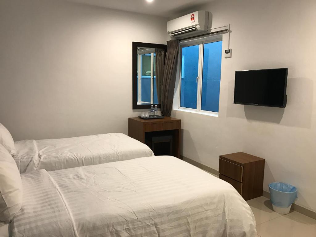 Postel nebo postele na pokoji v ubytování Brezza Hotel Sitiawan