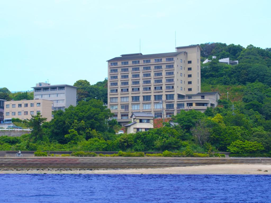 un edificio en la orilla de un cuerpo de agua en Kaiyoukaku, en Gamagori