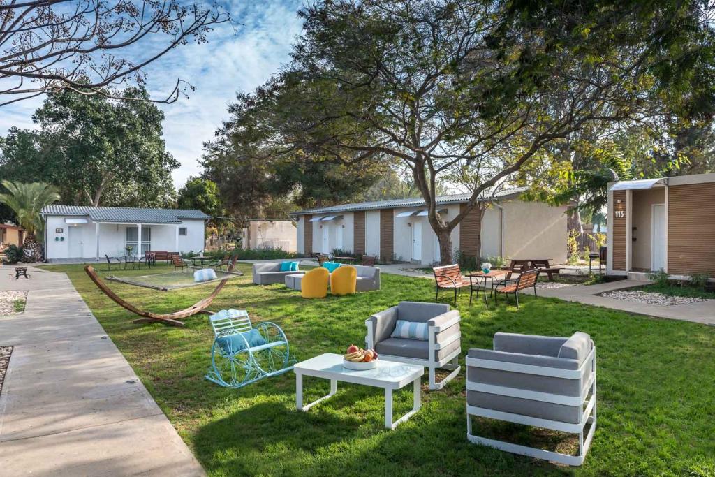 um quintal com cadeiras e uma mesa na relva em Eretz Zeelim em Ẕeʼelim
