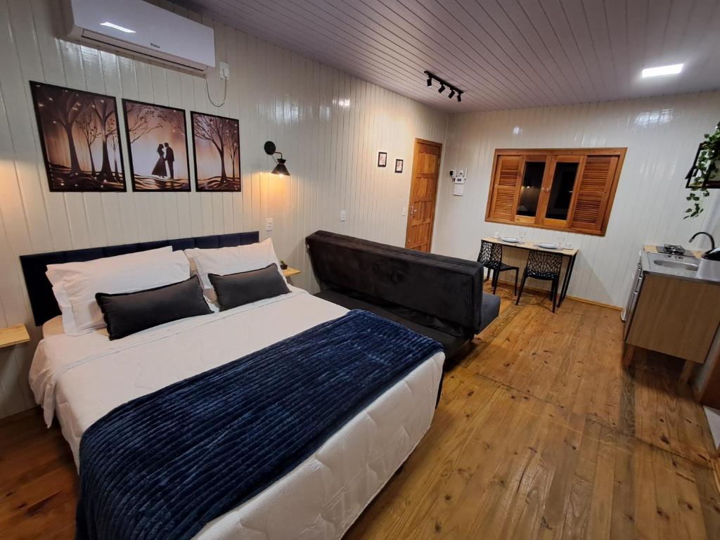a bedroom with a large bed and a couch at Casa VNE 01 in Araranguá