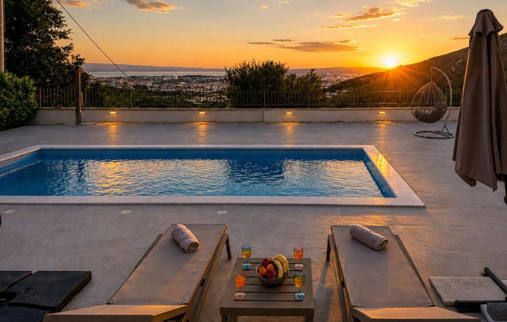 a swimming pool with a sunset in the background at Gorgeous Home In Solin in Solin