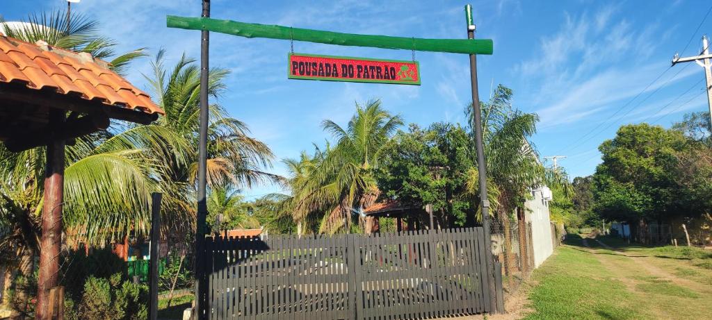 a sign on a fence in front of a house at Hotel E Pousada do Patrão in Bataguaçu