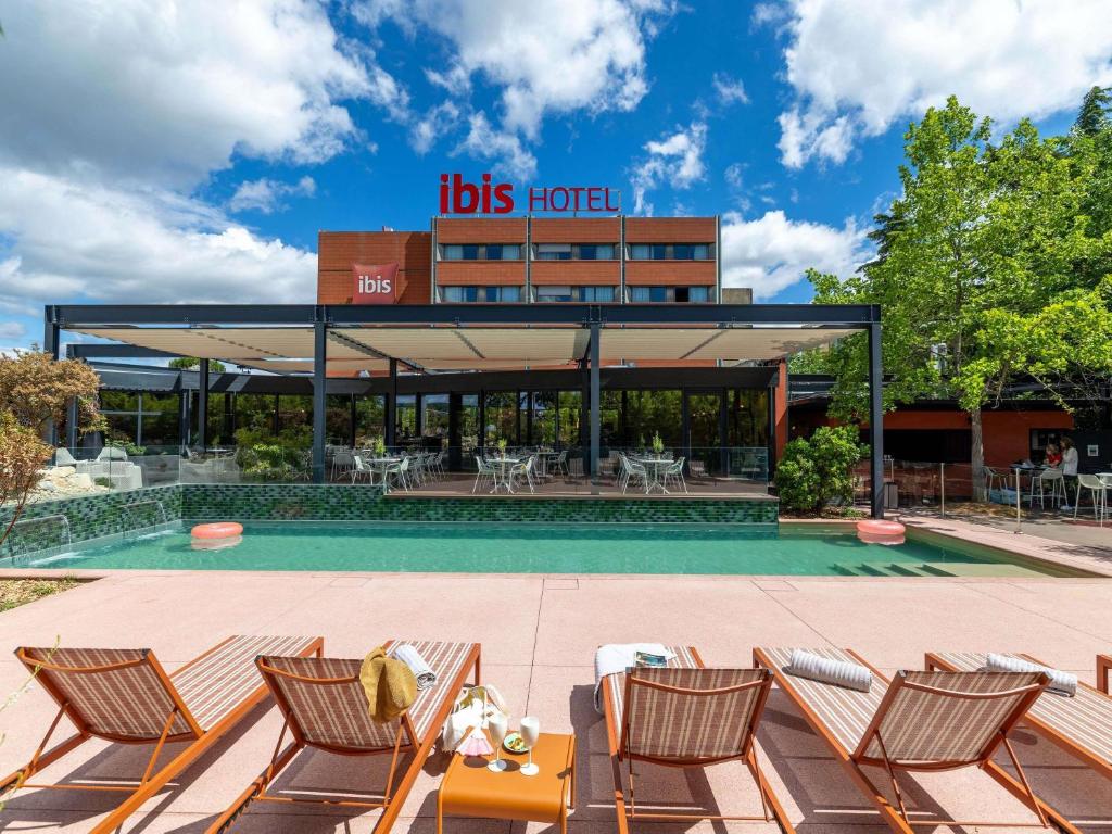 a hotel with chairs in front of a building at ibis Valence Sud in Valence
