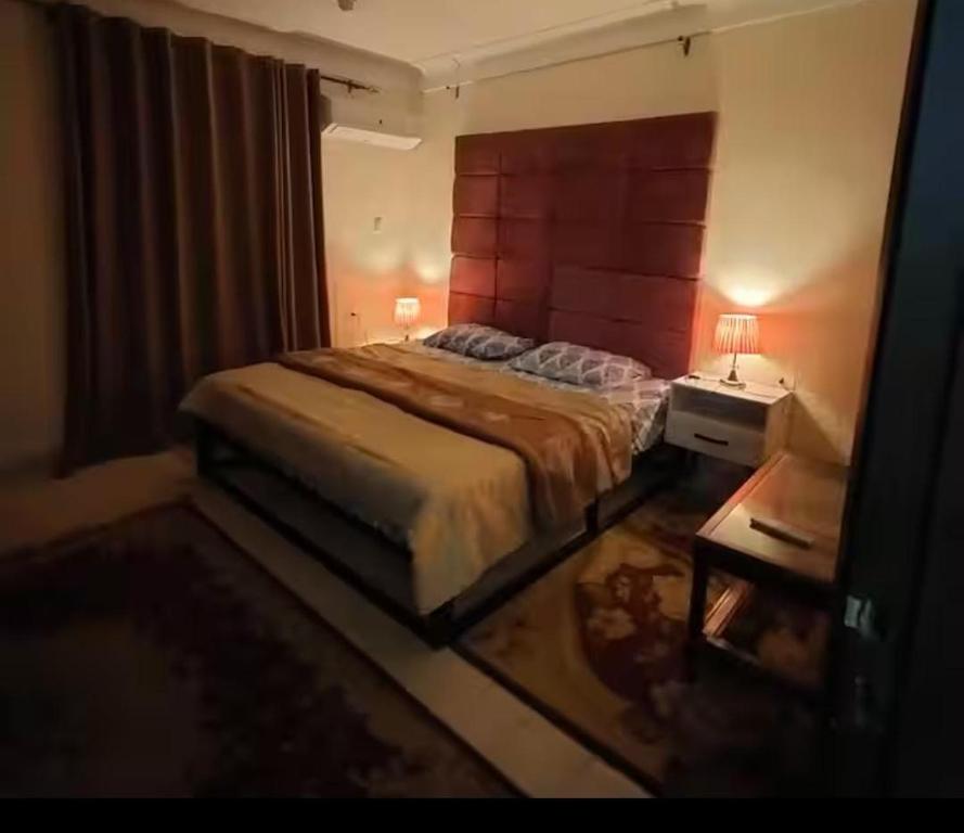 a bedroom with a large bed and a table at فيلا تسنيم للعائلات in Naj‘ al Aḩwāl