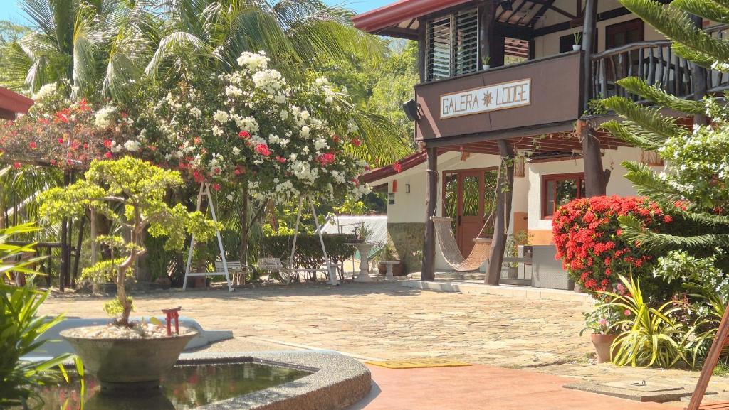 a building with a fountain in the middle of a courtyard at Galera Lodge & Cafe in Puerto Galera