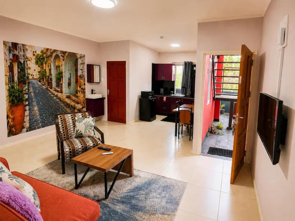 a living room with a couch and a table at DOLFIJN STUDIOS Stylish 2BR Apartment Fast WiFi AC Near Center in Paramaribo