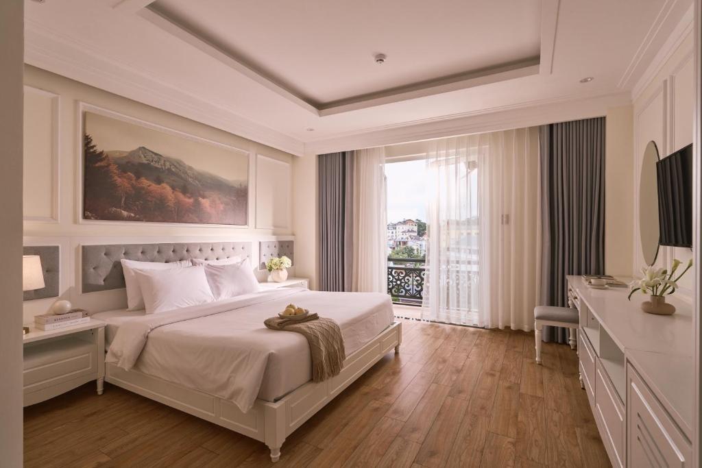 a bedroom with a large bed and a large window at Nature Hotel and Suite in Da Lat