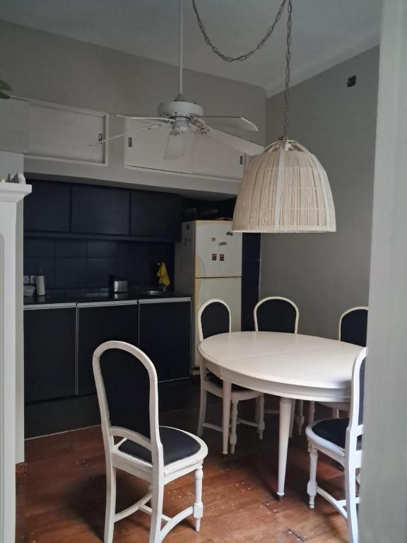 a kitchen with a table and chairs and a white table and chairs at Ana Ines in Santiago del Estero