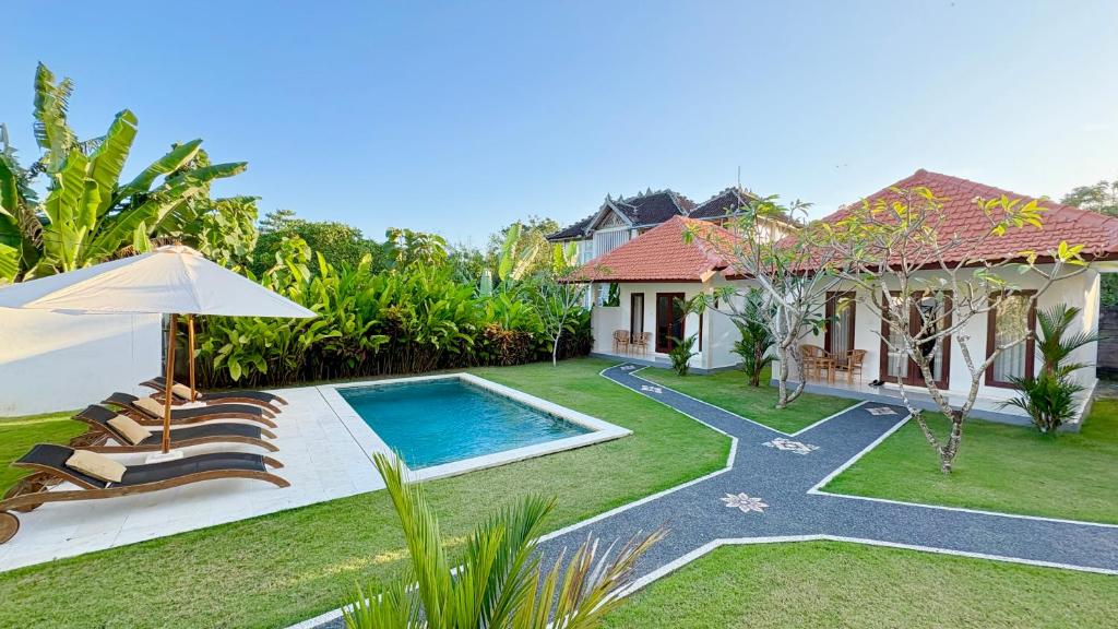 a backyard with a swimming pool and a house at ANANDA Bingin Guesthouse in Bingin Beach