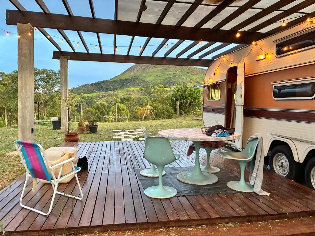 an rv with a table and chairs on a deck at Tiny house móvel com vista 360 in São Roque