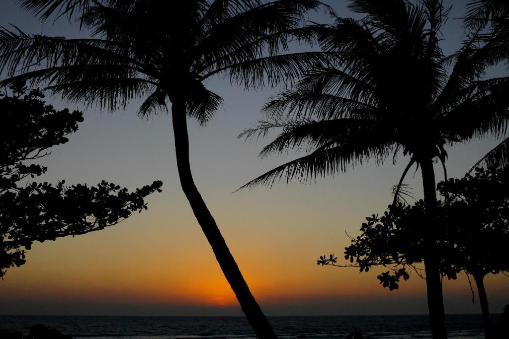 two palm trees on the beach at sunset at Yoho Beach Resort Kenting in Hengchun