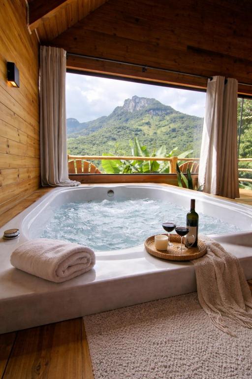a bath tub with a view of a mountain at cabana Eco da Natureza in Praia Grande