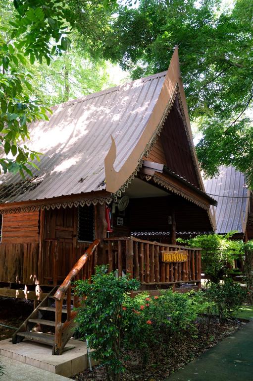a small wooden building with a metal roof at Akchanok Homestay - Nature Retreat in Phitsanulok