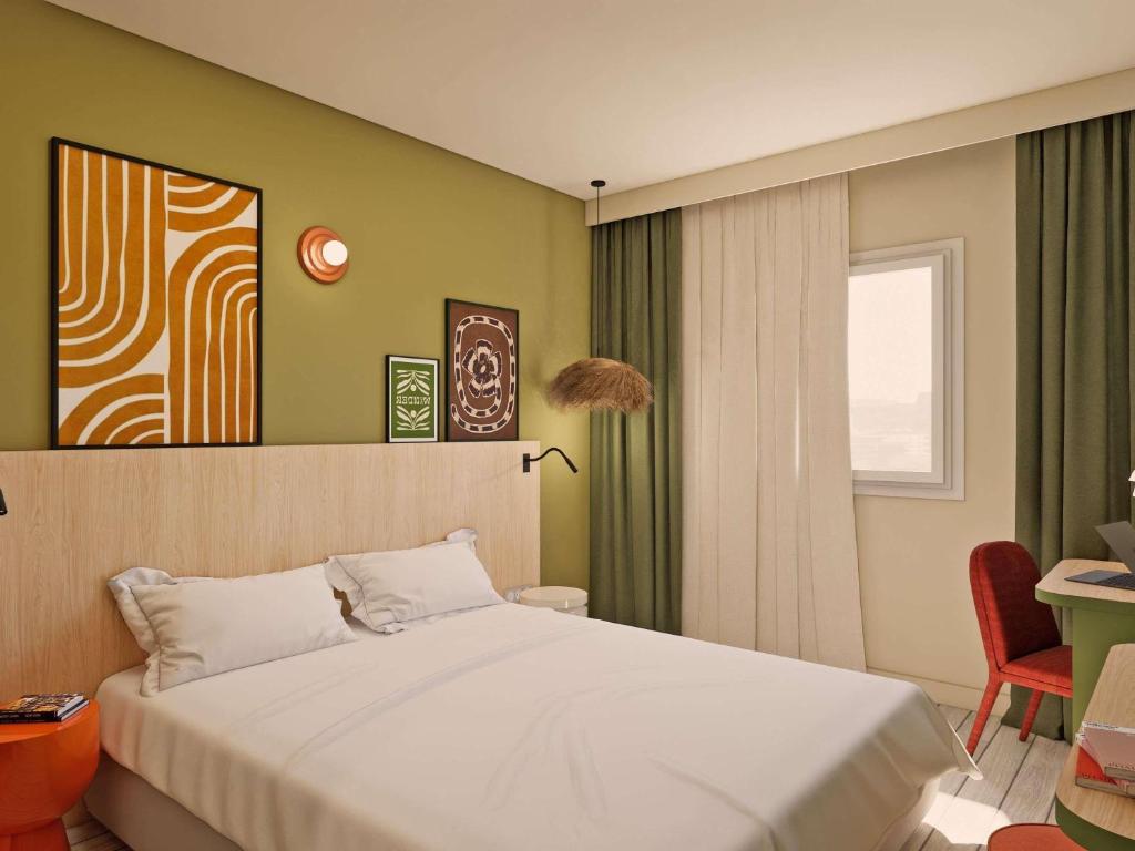 a bedroom with a white bed and a window at Ibis Styles Vannes Pte Golfe in Vannes