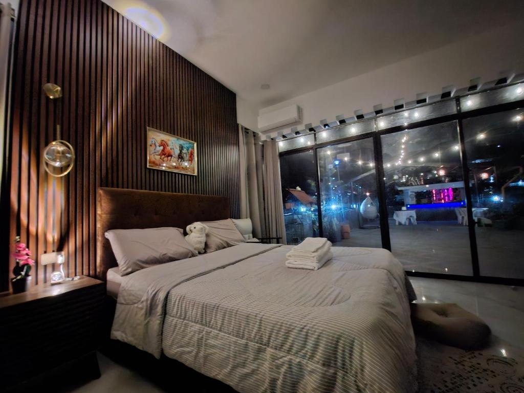 a bedroom with a large bed and a large window at Buddy's Skybar & Suite in Guinsorongan
