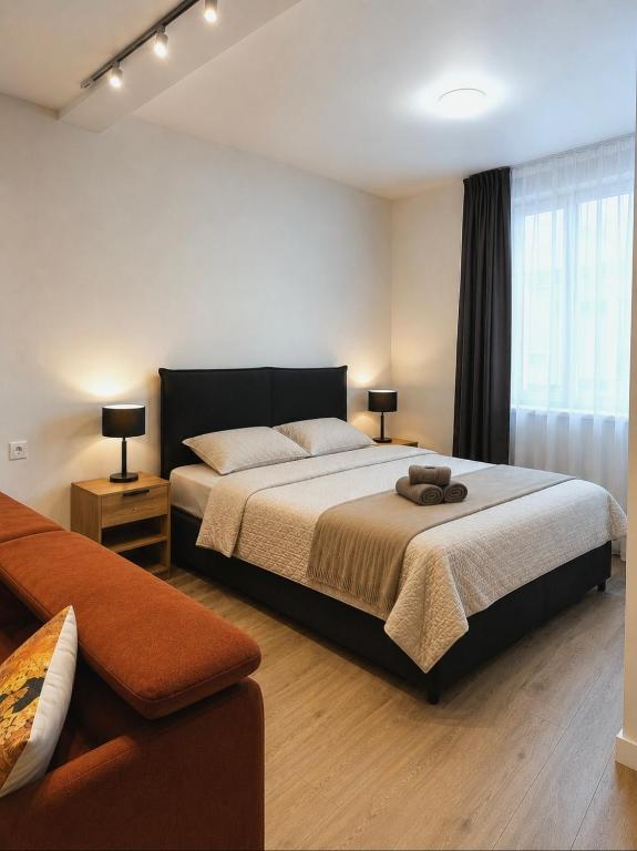 a bedroom with a large bed and a couch at Mažvydo Alėjos Self Check-In in Klaipėda
