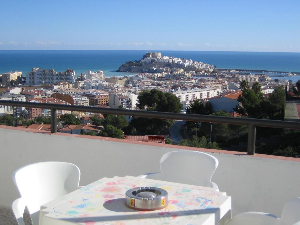 a table and chairs with a view of the city at Apartamentos Panoramica in Peniscola