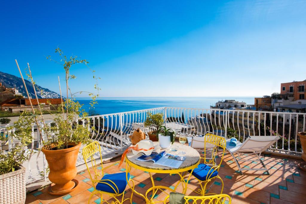 
a patio area with chairs, tables, and umbrellas at Hotel Villa Delle Palme in Positano in Positano
