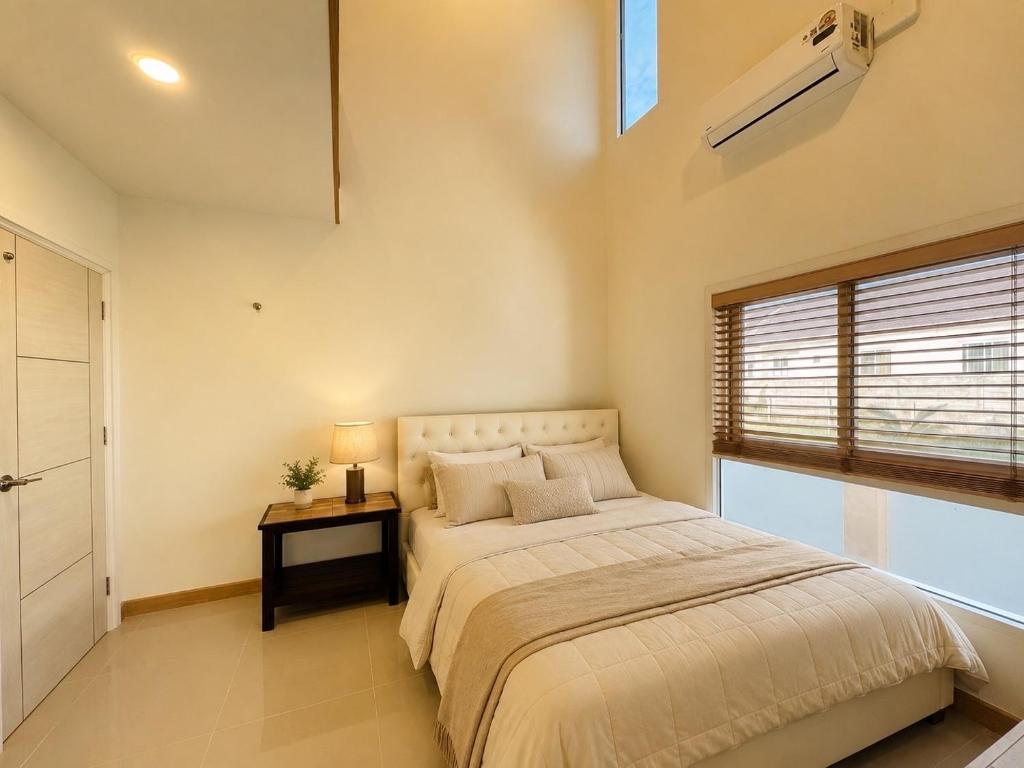a bedroom with a large bed and a window at พิภูตะวัน วิลล่า in Ban Luam