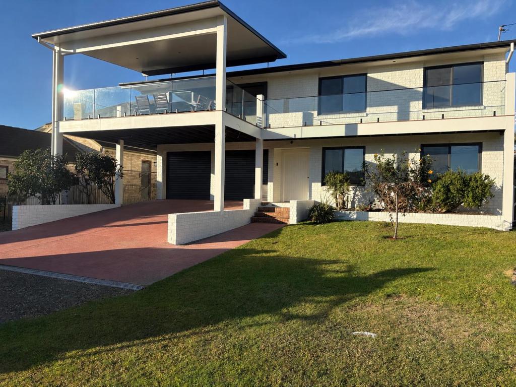 a large white house with a lawn in front of it at Beach N Berms in Dalmeny