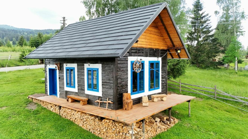 a tiny house on a wooden platform in a field at Cabana Vatra Plaiului in Şarul Dornei