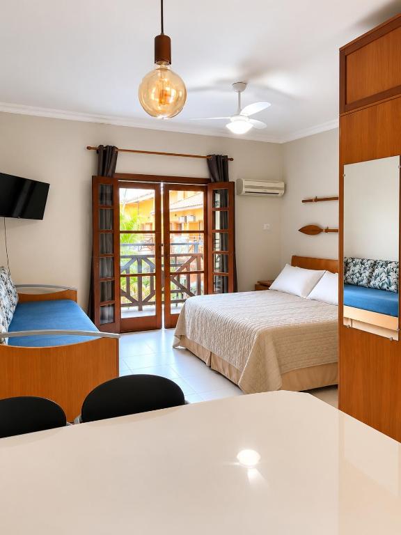 a hotel room with two beds and a television at Ilha Flat Apto 3207 in Ilhabela