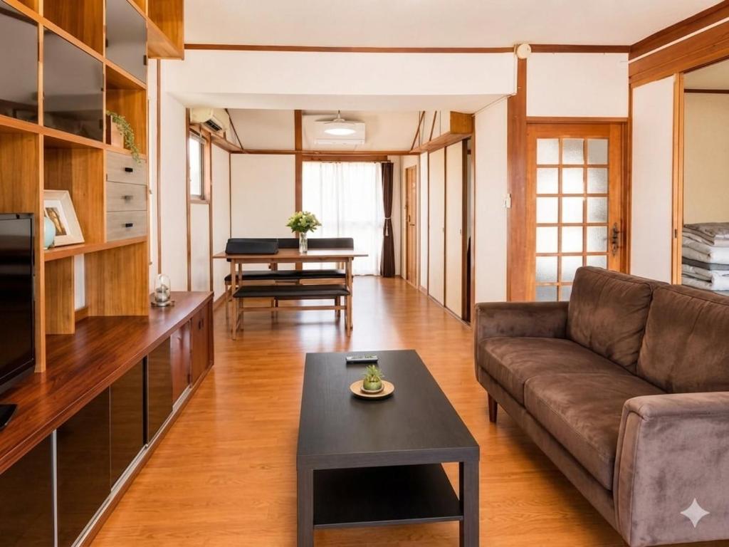 ein Wohnzimmer mit Sofa und Tisch in der Unterkunft Rumble Base 山口県光市虹ヶ丘 in Hikari