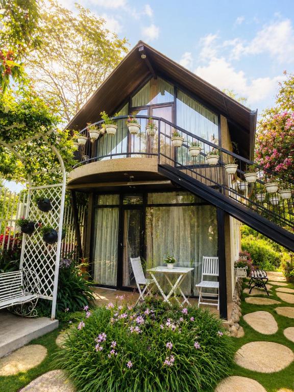 a house with a balcony and a patio at Up Tree Garden Đà Lạt in Xuan An