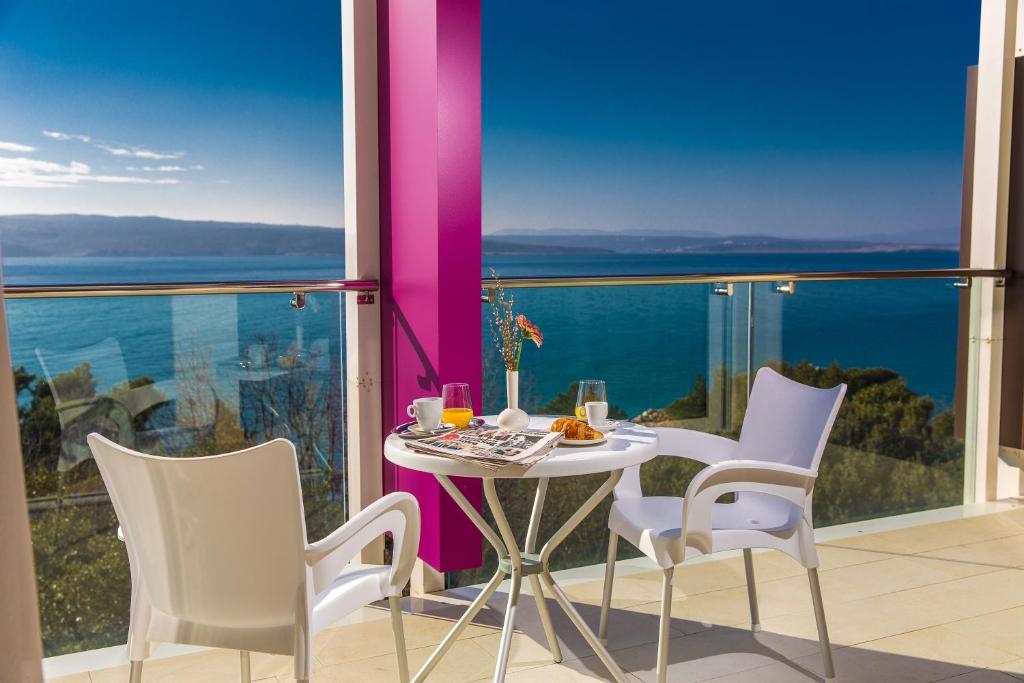 a table and chairs in a room with a view of the ocean at Hotel Crikvenica in Crikvenica